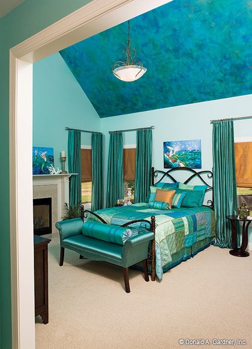 主卧室以凉爽的蓝色为特色。它包括一个大教堂的天花板，一个壁炉，一个华丽的木床和一个软垫长椅。