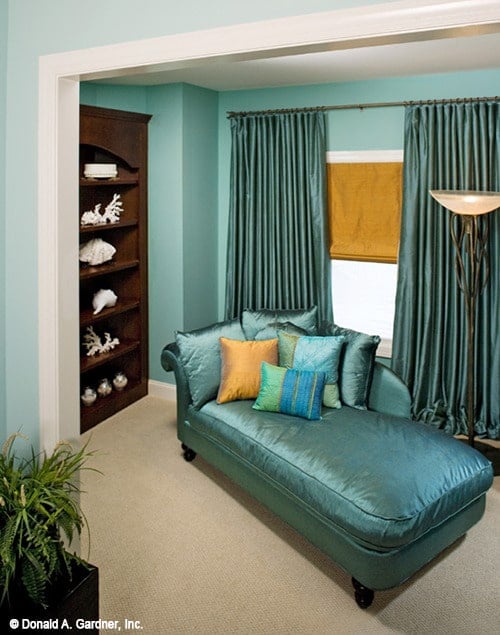 有深色木架子的客厅，一个优雅的躺椅休息室，和配套的窗帘。