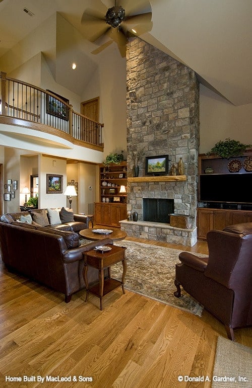 客厅有高高的拱形天花板，真皮座椅，和一个石质壁炉，两侧是木制嵌壁式家具。