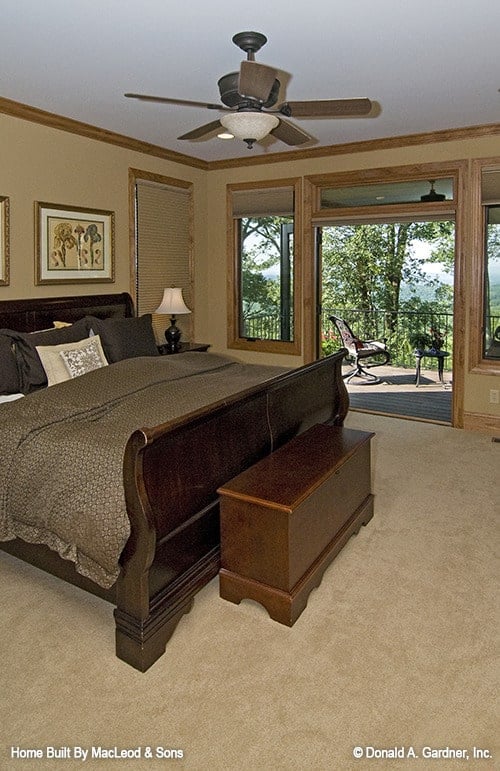 主卧室铺有地毯地板，深色木家具，并可直接进入门廊。