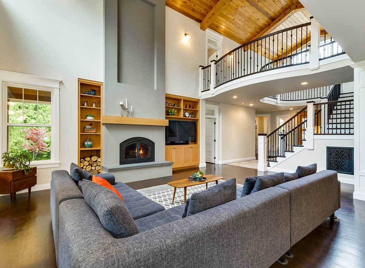 客厅里有一张l型沙发和一座壁炉，两侧是木质内置家具。
