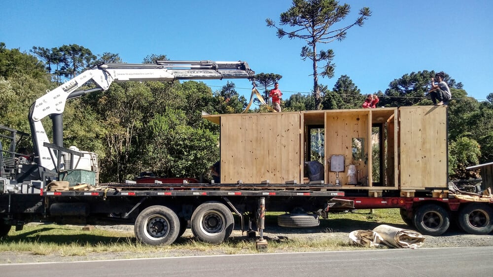 这是房屋建造过程中的一个视图，它的部分被卡车运送。