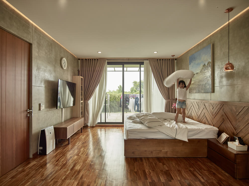 大的主卧室有一张木制台床，与硬木地板相匹配，辅以墙壁和玻璃门的自然光线。