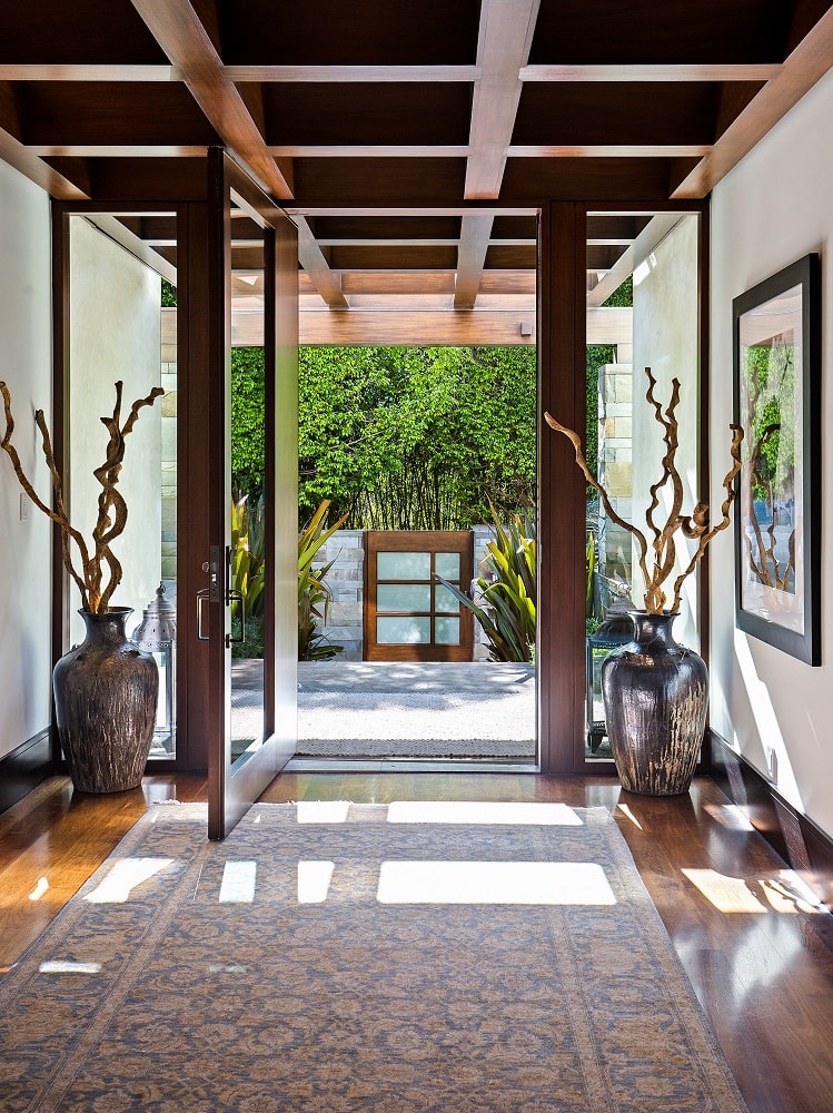 一进入房子，你就会受到这个明亮的门厅的欢迎，这里有一个木制的格子天花板，与玻璃门的木制框架和装饰着装饰品的墙壁相匹配。图片来自Toptenrealestatedeals.com。