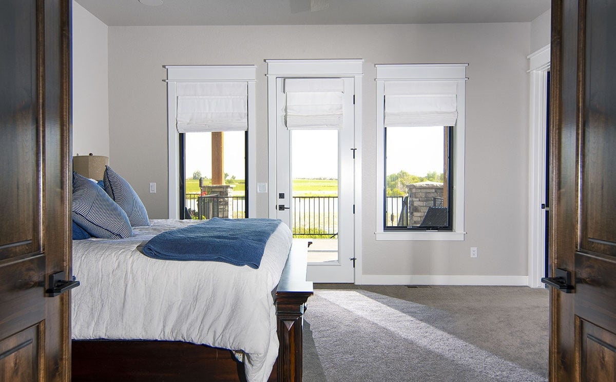 主卧室设有舒适的木床和私人甲板，可通过玻璃门进入。