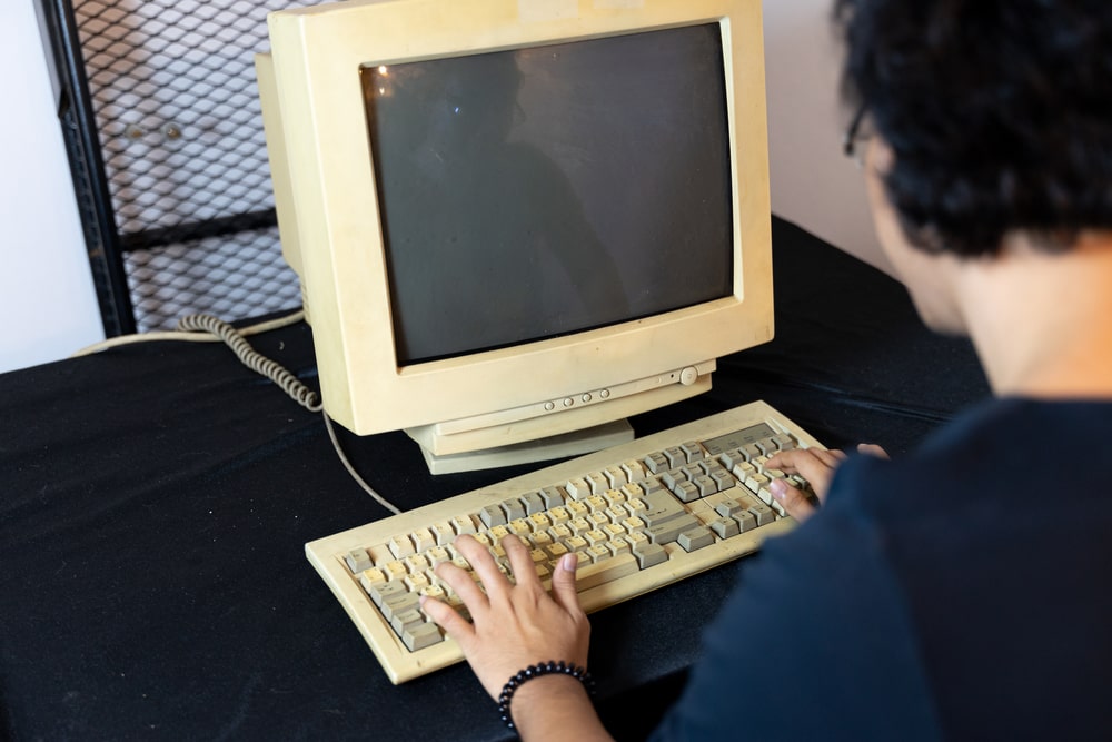 一个男人正在使用一台旧的个人电脑。