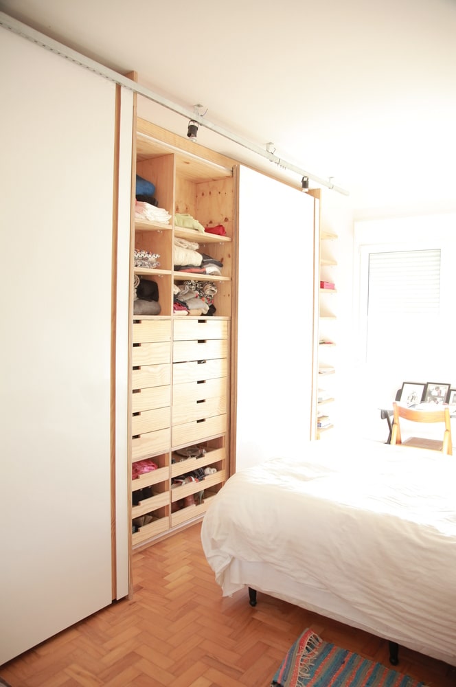 卧室里也铺着人字形木地板，床的一侧还有一个小书房。