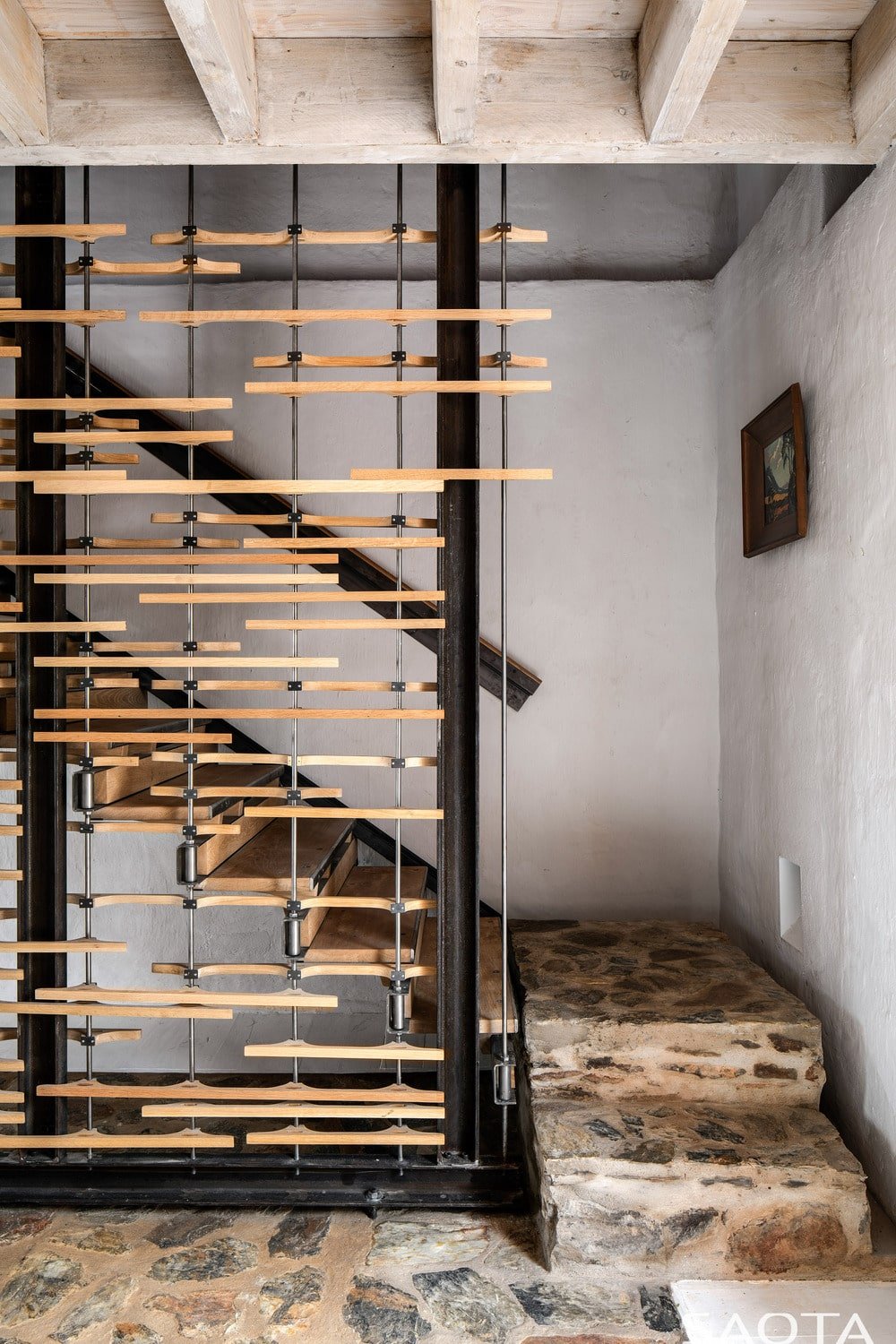 这是一个近距离观察楼梯的情况，台阶与镶嵌的乡村石头地板相匹配，并在侧面装饰了木材。
