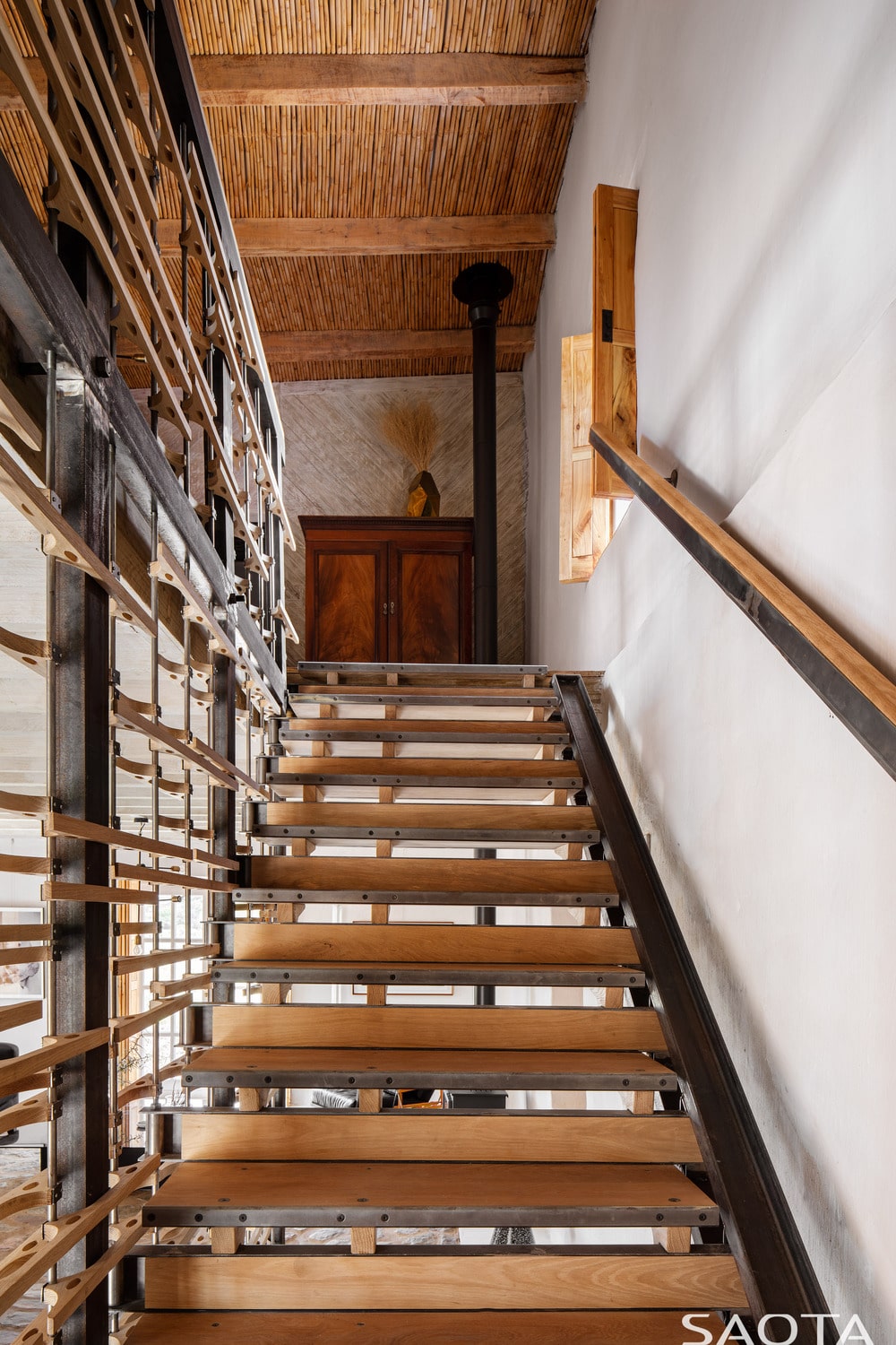 这是一个带有木制台阶的楼梯，侧面有一个木制窗户，上面的平台上有木制梳妆台。