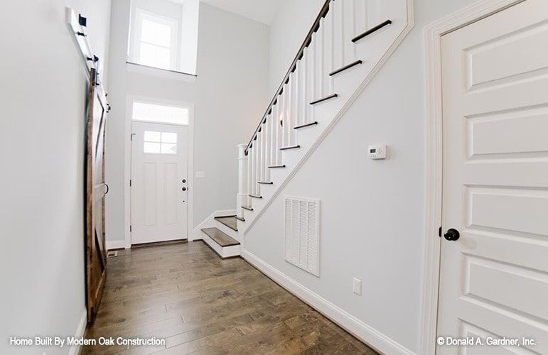 门厅有一扇白色的入口门，一扇天窗，还有一段通往家庭卧室的楼梯。
