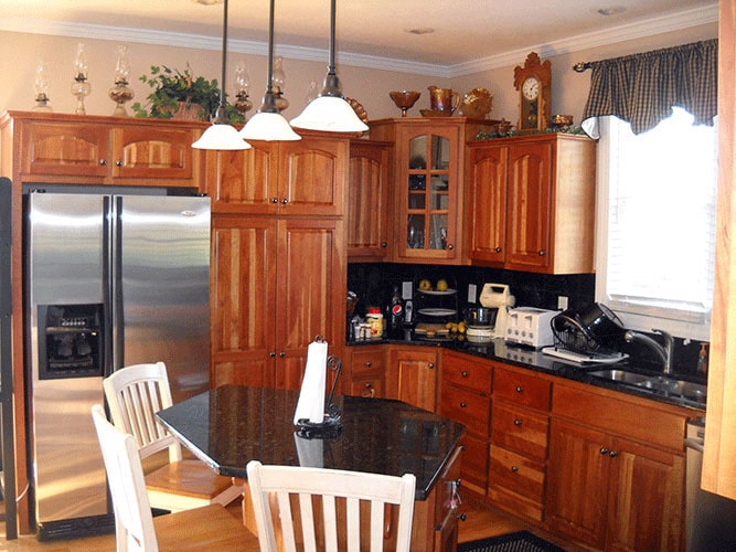 厨房提供木制橱柜，黑色花岗岩台面，不锈钢电器，和一个小的中心岛。