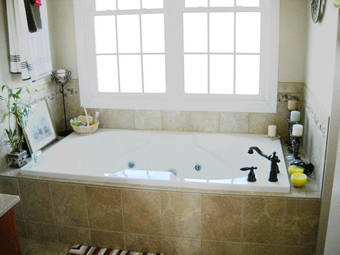 主浴室设有深浴缸，白色框窗下放置有铁装置。