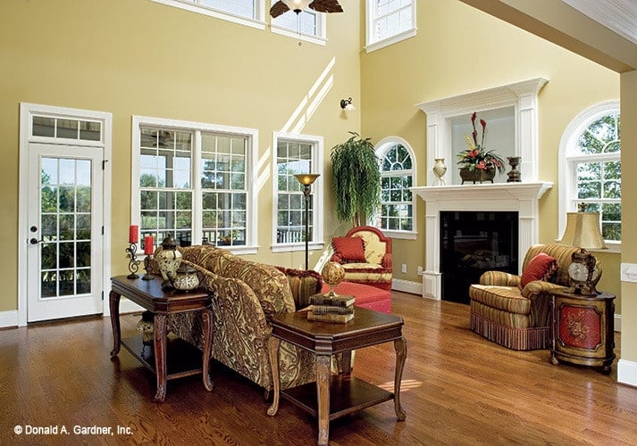 客厅与经典的座椅，木桌，壁炉两侧的拱形窗户。