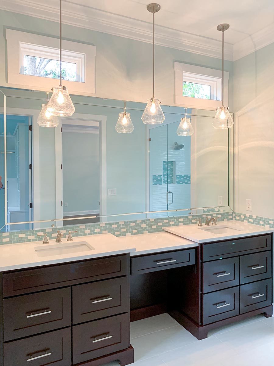 主浴室设有一个双水槽梳妆台，配有一面大矩形镜子和玻璃挂件。