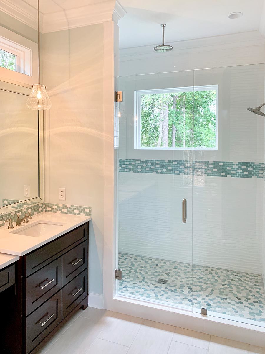步入式淋浴间，镀铬固定装置，马赛克瓷砖地板，玻璃铰链门。
