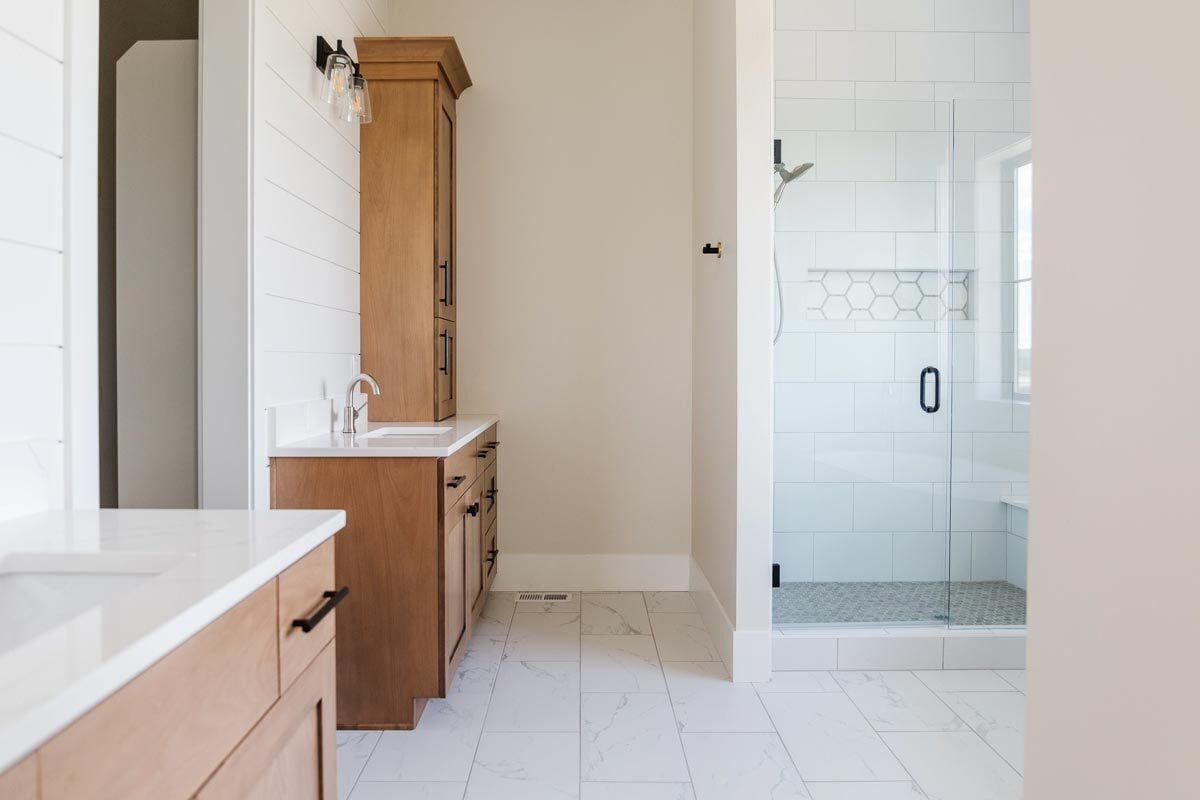 主浴室配有木制橱柜和大理石台面。