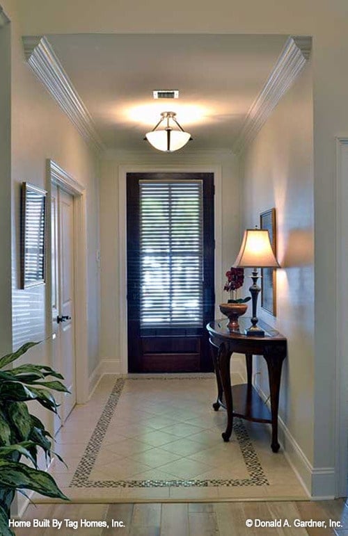 门厅里有一张木制的控制台桌子和温暖的灯光，营造出舒适的氛围。