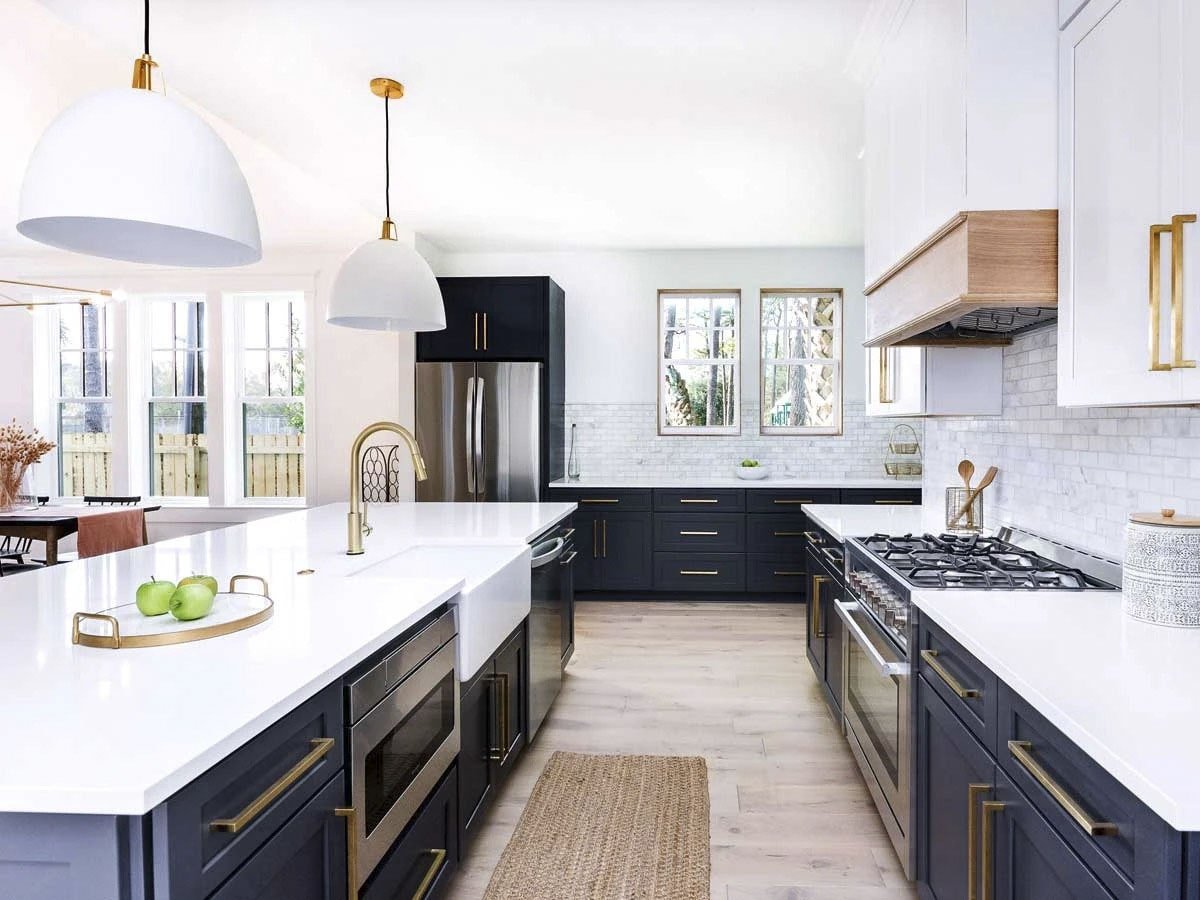 厨房里有对比鲜明的白色和黑色橱柜，配以黄铜固定装置。