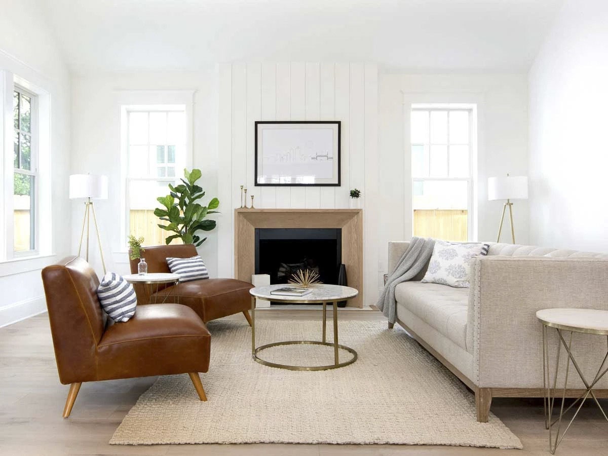 客厅有绒沙发，皮椅，圆形咖啡桌，和一个舒适的壁炉。