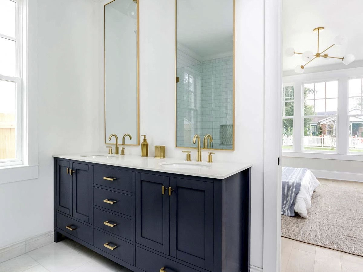 主浴室设有一个带有黑色橱柜和黄铜装饰的双洗手台。