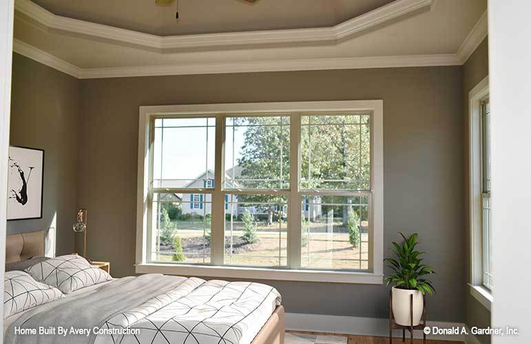 主卧室有优雅的托盘天花板和三扇窗户，邀请自然光进入。