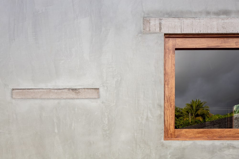 这是一个近距离观察混凝土外墙和突出的木制窗户框架。