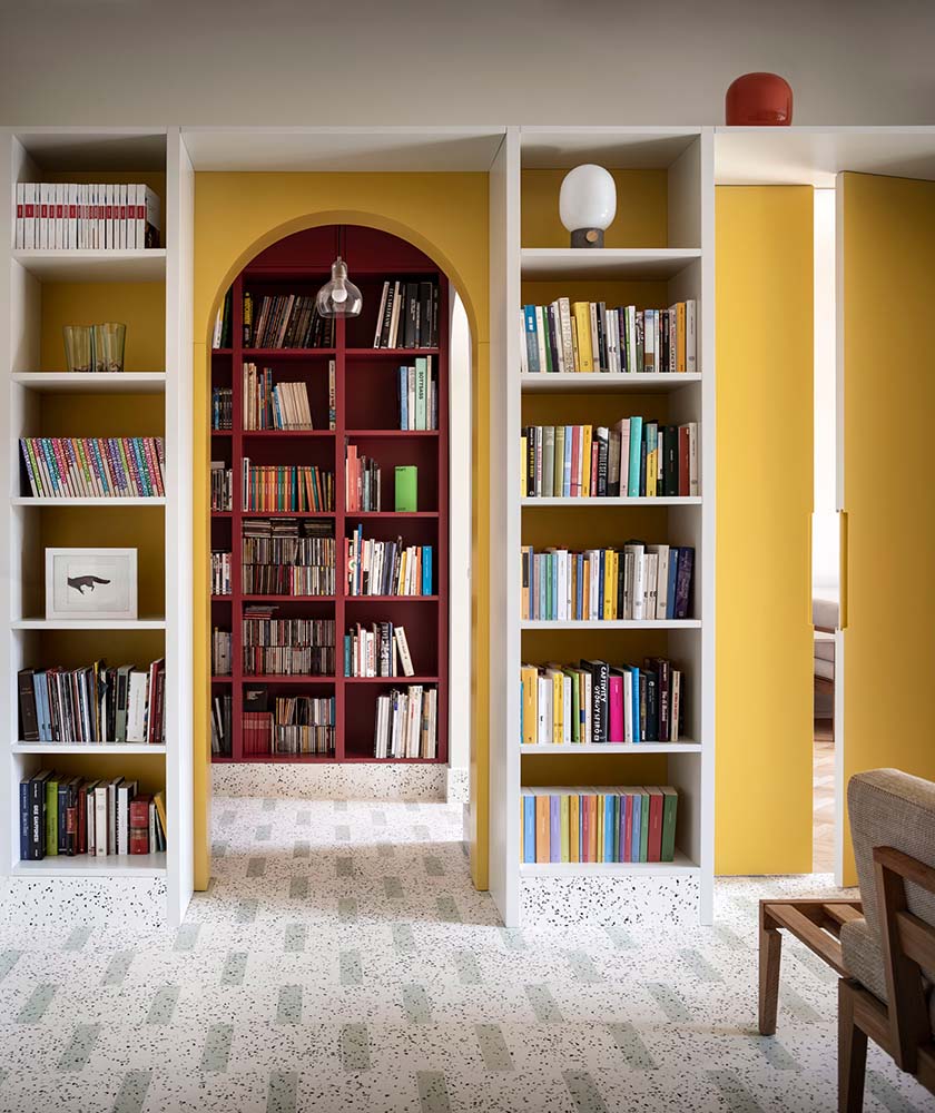 这是一个近距离观察房子的墙壁，内置书架和拱门与淡黄色的墙壁融合在一起。