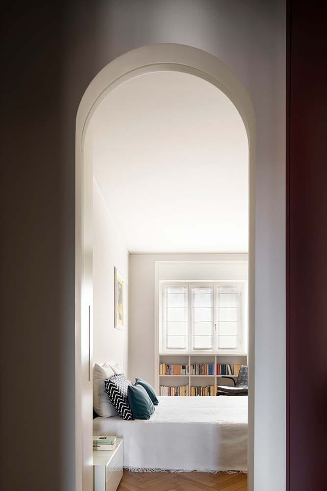 这是另一个拱形入口，通往卧室，卧室的另一侧有一张大床和嵌壁式书架。