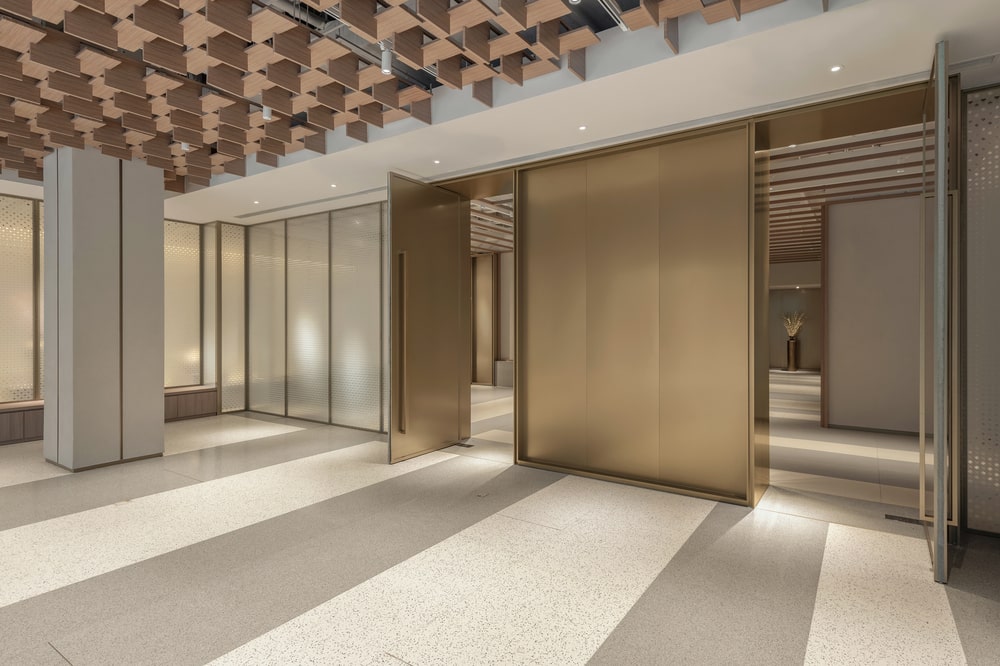 这是一个内部外观，展示条纹地板，天花板上的木板和光滑的黄铜门。