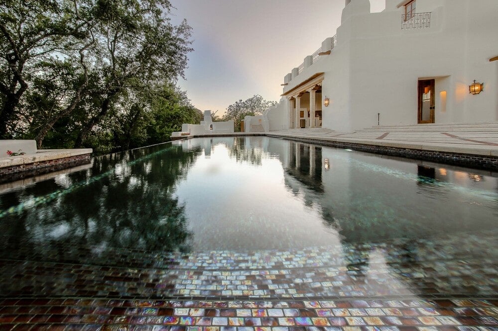 这是一个近距离观察无限边缘的游泳池，它为房子外部明亮的土坯墙带来了色彩。图片来自Toptenrealestatedeals.com。