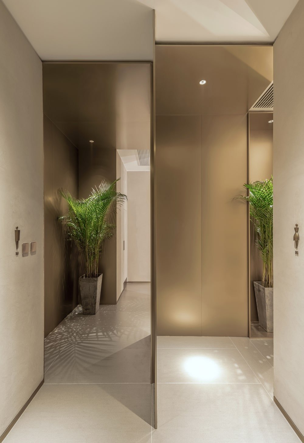 这是一个近距离观察男性和女性舒适室的入口，装饰着盆栽植物。