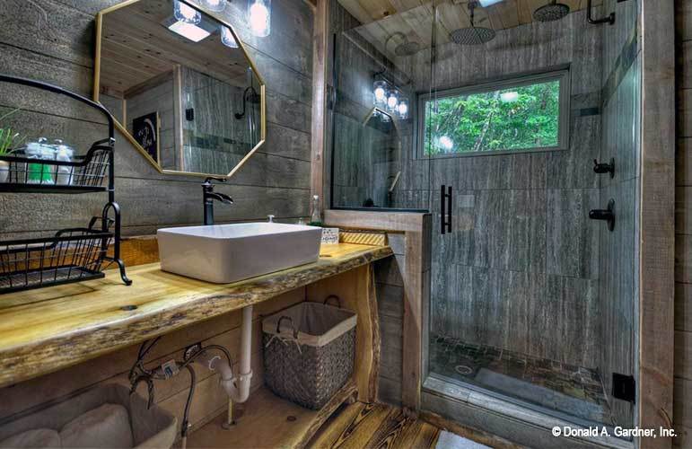 主浴室设有步入式淋浴间和木制梳妆台，配有一面八角形镜子。