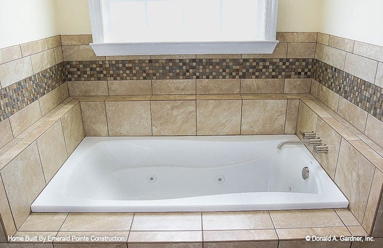 主浴室设有一个带有镀铬固定装置和大理石瓷砖环绕的插入式浴缸。