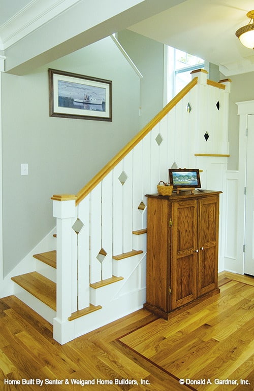 楼梯旁放着一个木柜，上面放着一张相框。