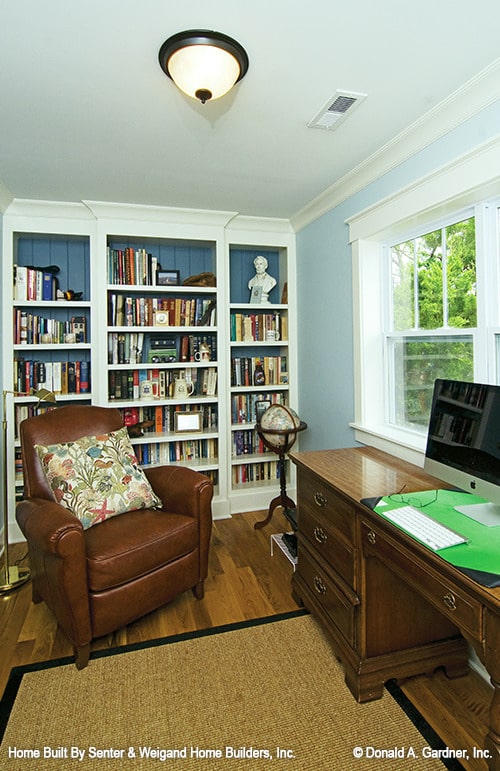 书房配有内置书柜，皮革扶手椅，木桌和黄麻地毯。