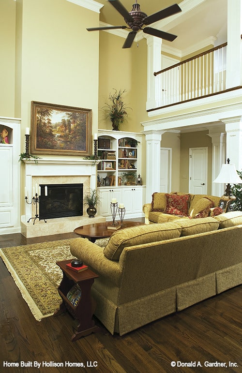 客厅有带裙边的座椅，经典的区域地毯，壁炉顶部有一幅山水画。