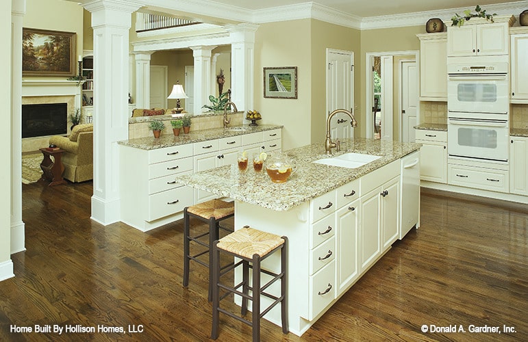 厨房有白色电器，定制橱柜，一个中心岛，和一个凸起的吃吧。