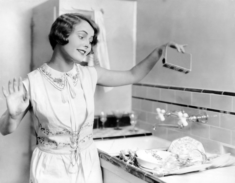 一个女人洗盘子的老式照片。