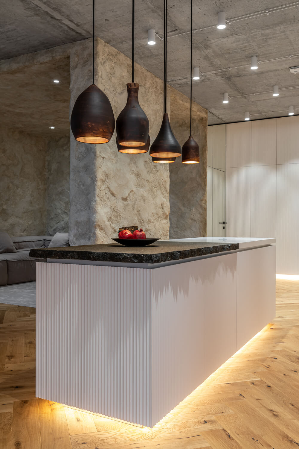 这是厨房岛的另一个视图，展示了更多的现代照明，它靠近客厅的墙壁。