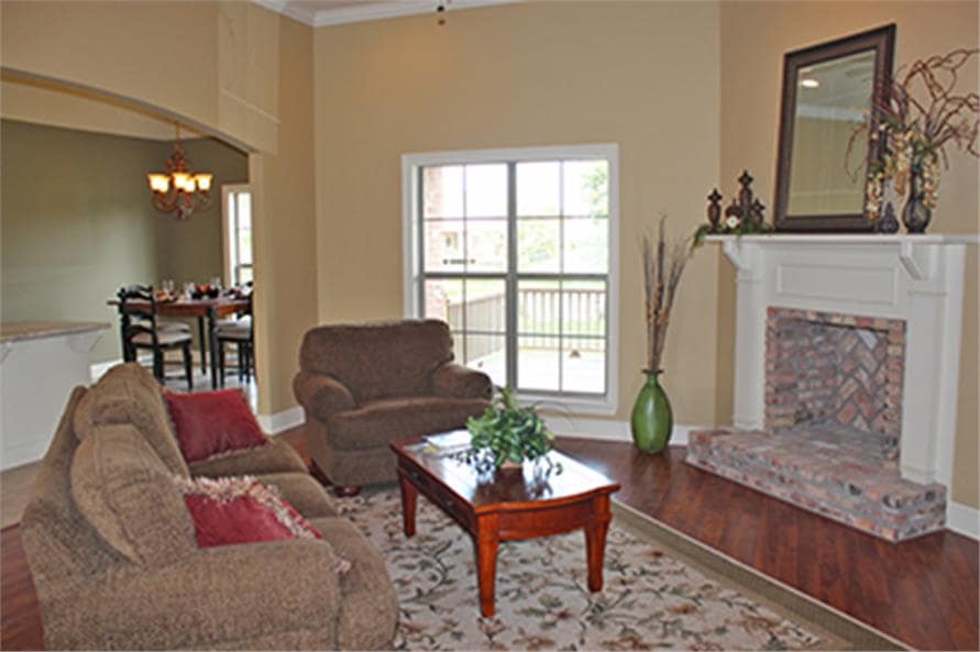 客厅里有棕色的椅子，一张木制的咖啡桌，角落里的壁炉装饰着一面镜框和一些古董花瓶。