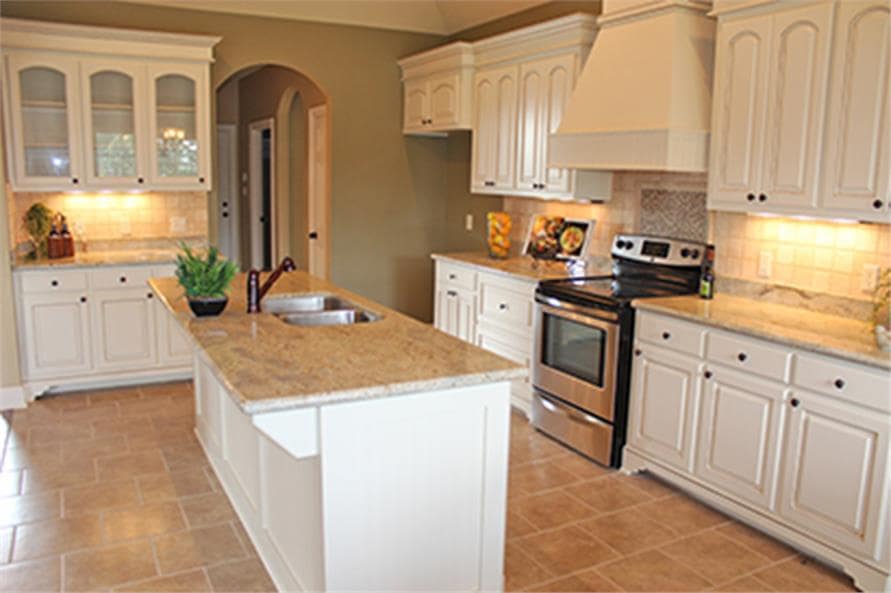 厨房提供白色橱柜、花岗岩台面、不锈钢炉灶和一个安装在岛上酒吧的双碗水槽。