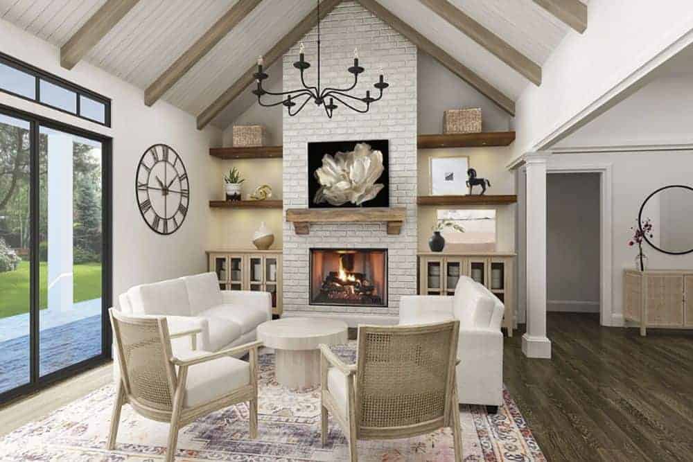 客厅里有白色沙发、软垫扶手椅、一张圆形咖啡桌和一座砖砌壁炉。它的顶部是一个大教堂式的天花板，内衬着裸露的木梁。