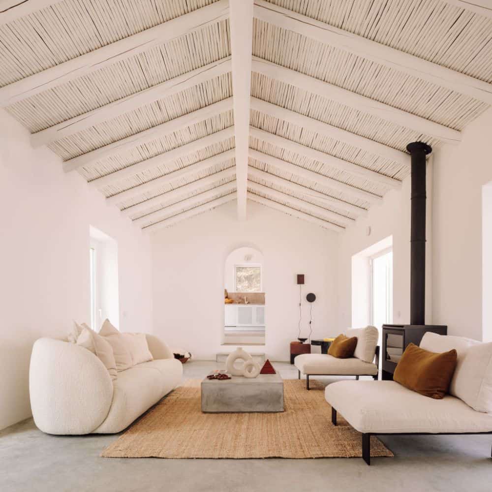 客厅的沙发组与米黄色的墙壁和天花板相匹配，而混凝土咖啡桌与地板相匹配。