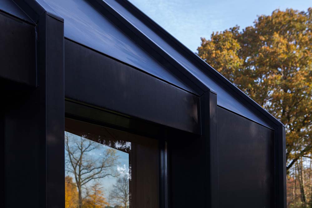 这是一个近距离观察现代结构的黑色外墙材料和它的玻璃窗。