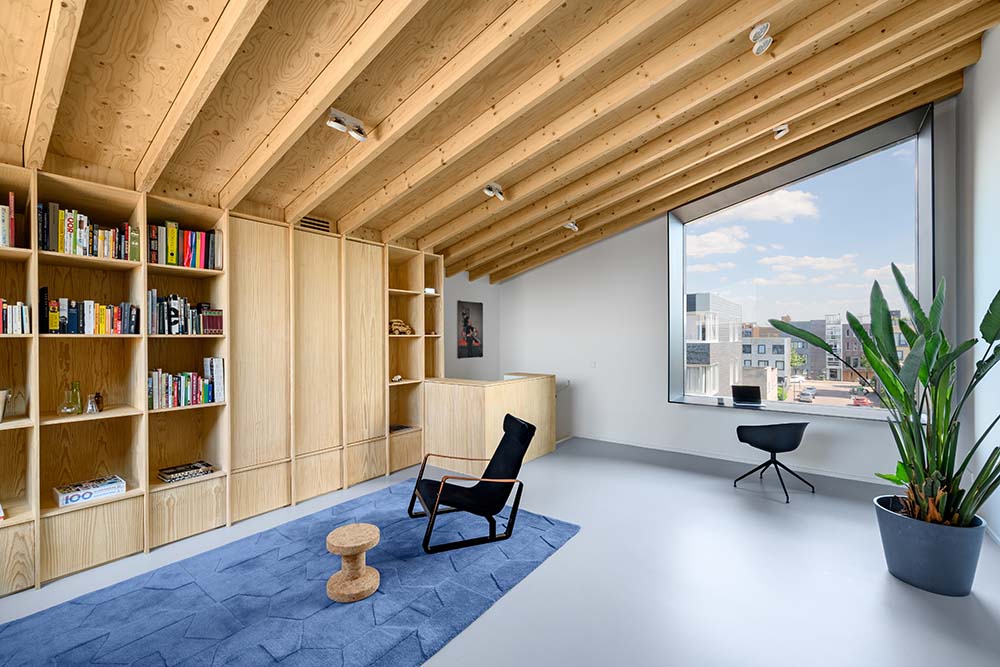 内置的木质书架结构与低矮棚顶的裸露横梁很好地融合在一起。