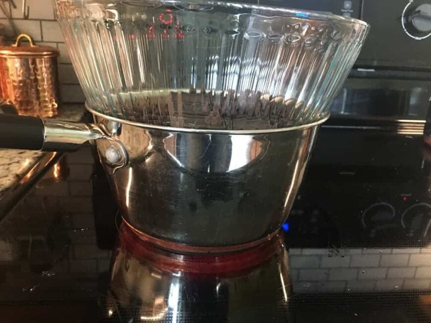 将一个玻璃搅拌碗放在一小壶热水上。