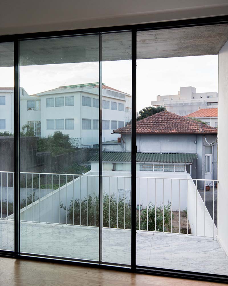 这张图可以近距离看到上层的玻璃推拉门，这扇门通向有白色栏杆的阳台，可以看到后院的花园。