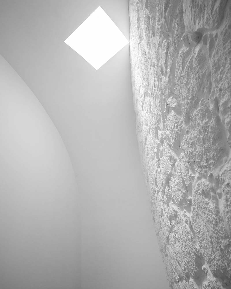 这是上层纹理墙顶部的近距离观察，它有一个方形天窗，可以引入自然光线。