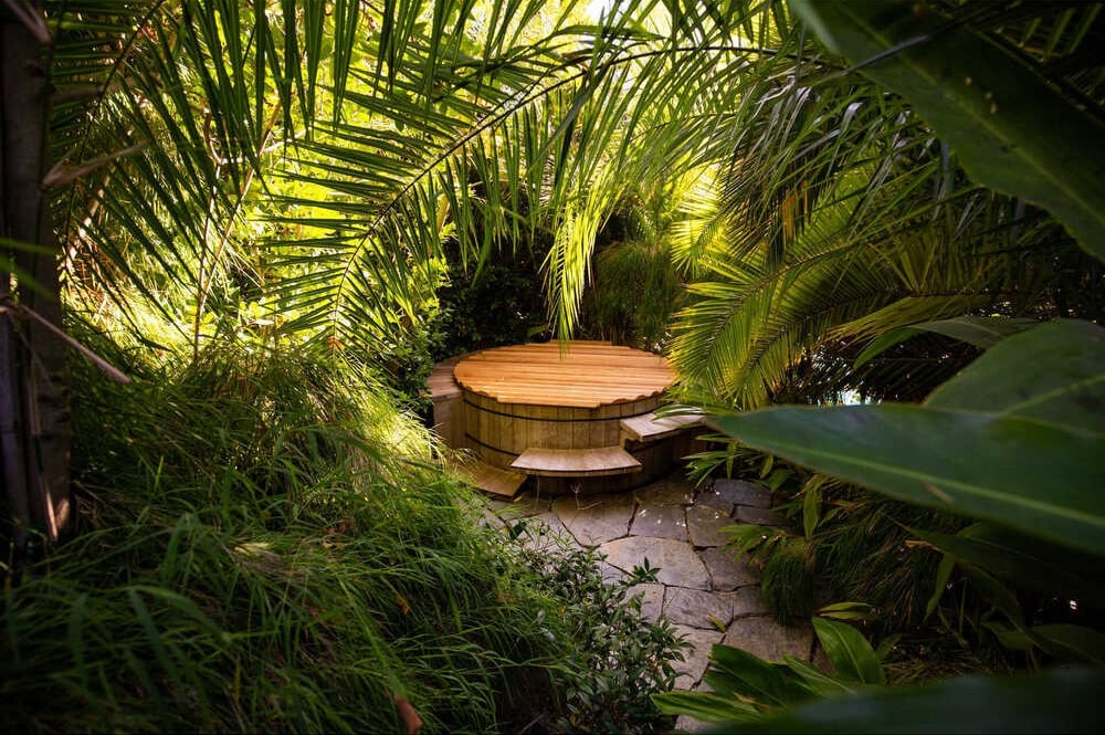 这个角落有一个隐藏的热水浴缸，坐落在茂密的灌木丛和高大的热带树木之间。图片来自Toptenrealestatedeals.com。