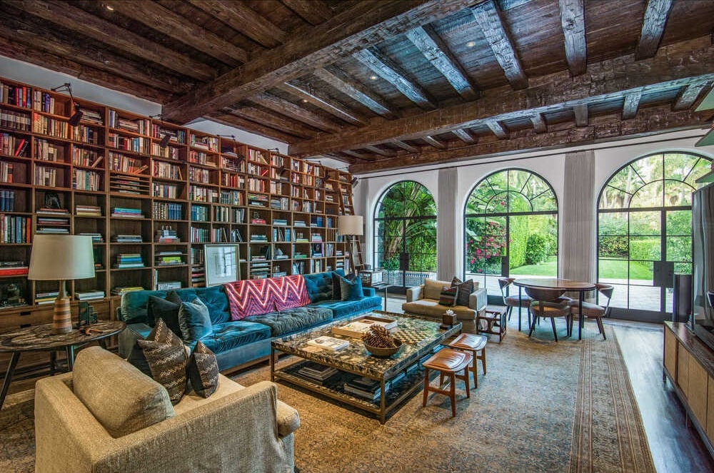 这个图书馆有一个高高的木制横梁天花板，与沙发后面的内置书架相匹配。图片来自Toptenrealestatedeals.com。